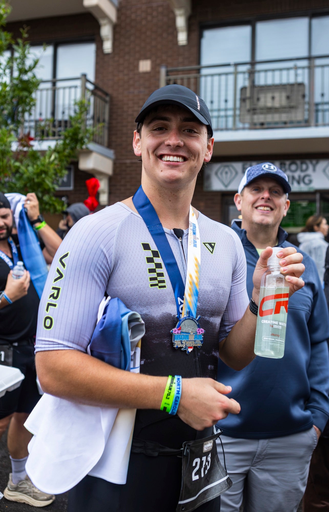 Athlete with a finisher medal holding a Creset bottle